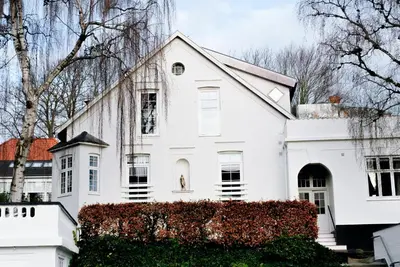 a white house with a statue in the window at Villa Apartments Viborg in Viborg