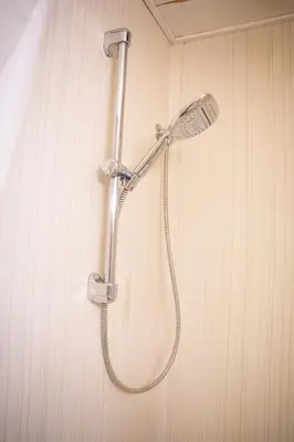 a shower with a shower head on a wall at Villa Apartments Viborg in Viborg