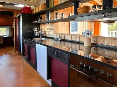 a large kitchen with wooden cabinets and a counter top at Architect-Designed Summer House In Agger in Vestervig