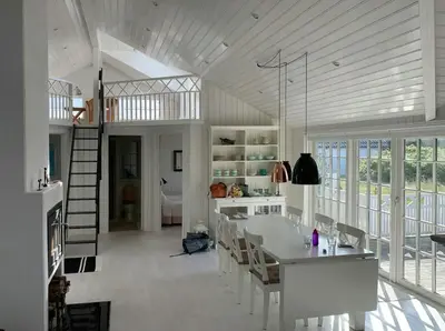 a white kitchen with a dining table and chairs at Home With Sauna Near Klitmøller in Thisted