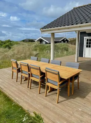 a wooden table and chairs on a wooden deck at Home With Sauna Near Klitmøller in Thisted