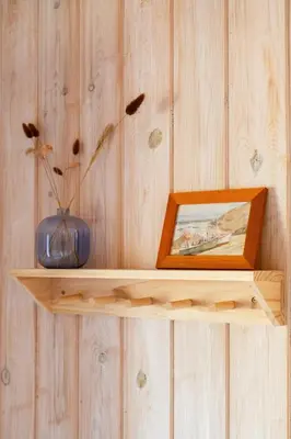 a wooden shelf with a picture and a vase on it at North Jutland Nature Near Thorup Beach in Fjerritslev