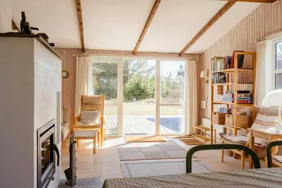 a living room with a fireplace and a sliding glass door at North Jutland Nature Near Thorup Beach in Fjerritslev