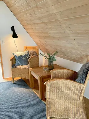 a living room with wicker chairs and a table at Architect-Designed Gem At The West Coast in Pandrup
