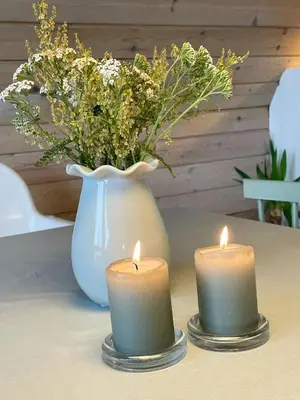two candles sitting on a table with a vase at Architect-Designed Gem At The West Coast in Pandrup