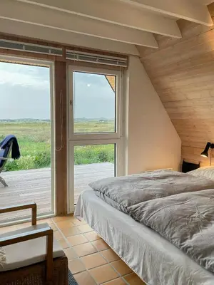 a bedroom with a bed and a large window at Architect-Designed Gem At The West Coast in Pandrup