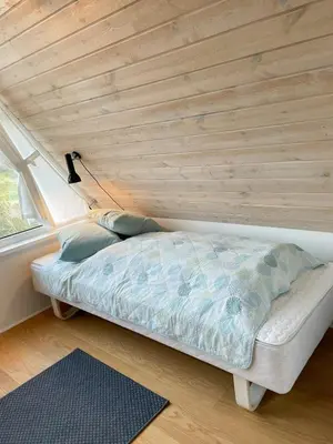 a bed in a room with a wooden ceiling at Architect-Designed Gem At The West Coast in Pandrup