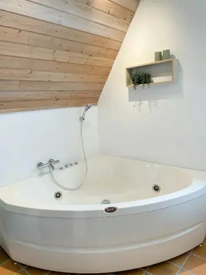 a white bath tub in a bathroom with a wooden ceiling at Architect-Designed Gem At The West Coast in Pandrup