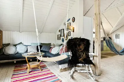 a person sitting in a room with a swing at Home By Limfjord Where Sea And Sky Meet in Hurup