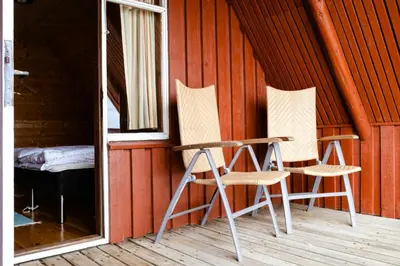 two chairs sitting on the porch of a cabin at Nature Gem 5 Metres From Limfjord in Roslev