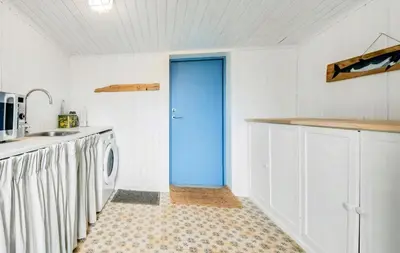 a blue door in a kitchen with a washing machine at Skipper House With Views Of The North Sea in Harboør