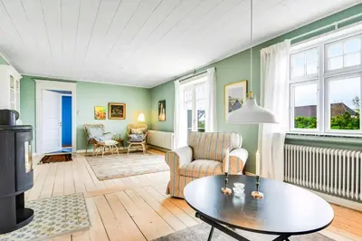 a living room with green walls and a table at Skipper House With Views Of The North Sea in Harboør