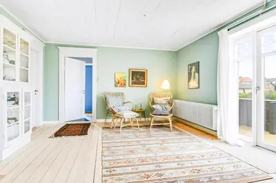 a living room with two chairs and a rug at Skipper House With Views Of The North Sea in Harboør
