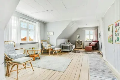 a living room with chairs and a table at Skipper House With Views Of The North Sea in Harboør