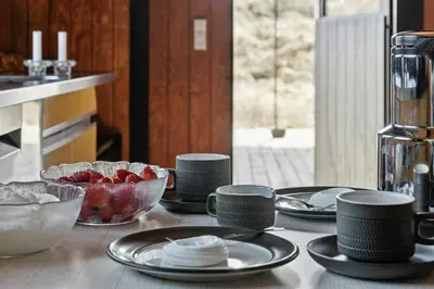 a table with plates and bowls of food on it at 70'S Style Summerhouse Near Løkken in Løkken