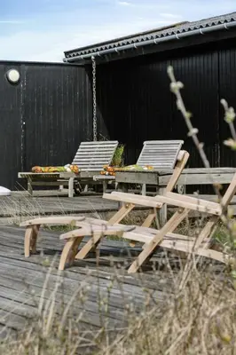 two chairs and a picnic table on a deck at 70'S Style Summerhouse Near Løkken in Løkken