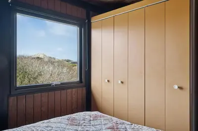 a bedroom with a window and a bed at 70'S Style Summerhouse Near Løkken in Løkken