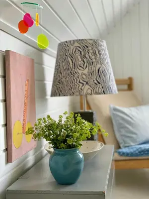 a blue vase sitting on a table with a plant at Cozy Summer House In Agger Near The North Sea in Vestervig