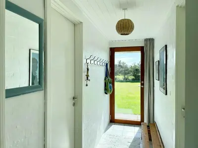 a hallway of a home with a door and a window at Cozy Summer House In Agger Near The North Sea in Vestervig