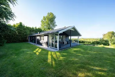 a small house with a large grass yard at Panoramic View And Terrace In Charming Home in Højslev