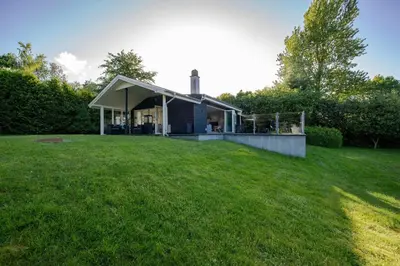 a house in a field with a grass yard at Panoramic View And Terrace In Charming Home in Højslev