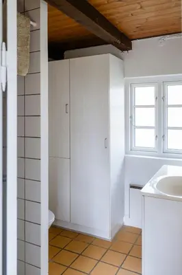 a bathroom with a toilet and a sink and a window at Small House With View Of The Limfjord in Roslev