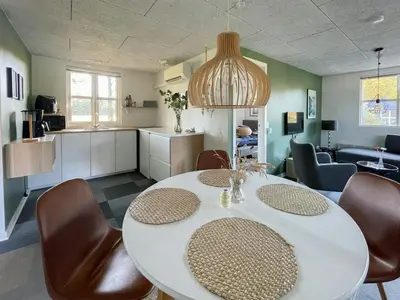 a kitchen and dining room with a table and chairs at Relax In The Countryside With Pool in Avlum
