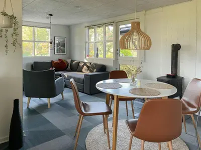 a living room with a couch and a table and chairs at Relax In The Countryside With Pool in Avlum