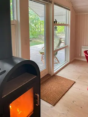 a fireplace in a room with a view of a porch at Virksund Home With Grounds And Hot Tub in Højslev