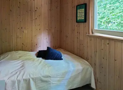 a room with a bed with a blue pillow on it at Home Near Beach With Wilderness Bath in Sindrup