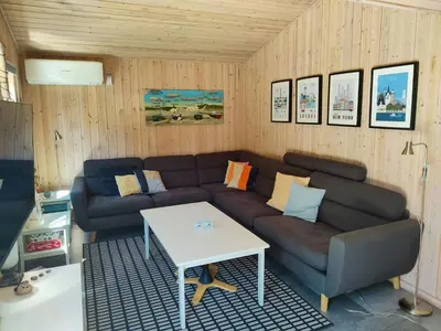 a living room with a couch and a table at Home Near Beach With Wilderness Bath in Sindrup