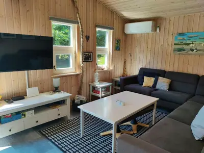 a living room with a couch and a tv at Home Near Beach With Wilderness Bath in Sindrup