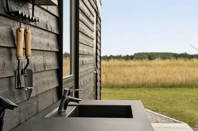 a kitchen sink with a view of a field at Modern Light House With Terrace Near The Fjord in Løgstrup