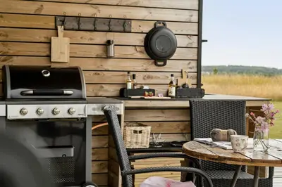 an outdoor kitchen with a table and a stove at Modern Light House With Terrace Near The Fjord in Løgstrup
