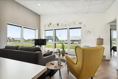 a living room with a couch and chairs at Modern Light House With Terrace Near The Fjord in Løgstrup