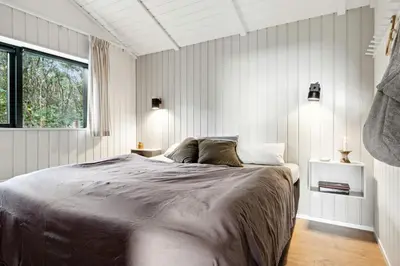 a bedroom with a large bed and a window at Cottage At Feggeklit With Limfjord Views in Nykøbing Mors
