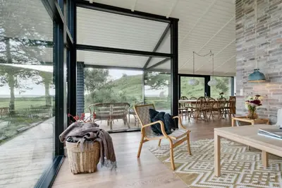 a living room with a table and chairs at Cottage At Feggeklit With Limfjord Views in Nykøbing Mors