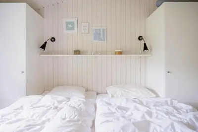 a white bed with two pillows in a bedroom at Bright And Lovely Summerhouse In Løkken in Løkken
