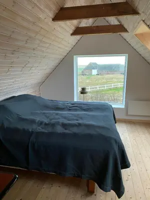 a bedroom with a large bed and a large window at Renovated Farmhouse In Architectural Style in Lemvig