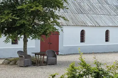 a table and two chairs in front of a building at Renovated Estate With Private Beach in Roslev