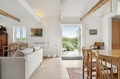 a living room with a couch and a table at Renovated Estate With Private Beach in Roslev
