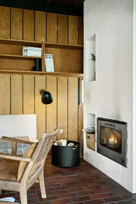 a living room with a fireplace and a chair at Authentic Friis & Moltke House In Lundo's Nature in Højslev