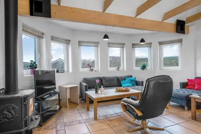 a living room with a couch and a stove at Large Holiday Home With Pool And Spa In The Middle Of Blokhus Town, Close To The North Sea in Blokhus