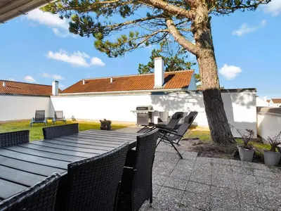 a wooden table with chairs next to a tree at Charming Retreat in Rodhus - By Traum Ferienwohnungen in Pandrup