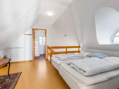 a bedroom with a large bed in a attic at Cozy Family Retreat - By Traum Ferienwohnungen in Blokhus