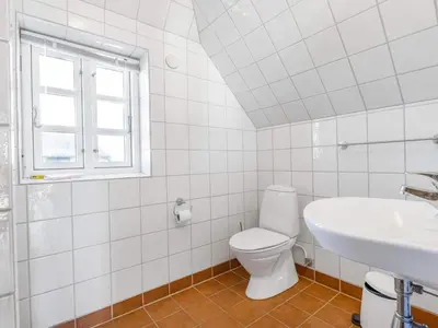 a white bathroom with a toilet and a sink at Charming Retreat in Blokhus - By Traum Ferienwohnungen in Blokhus