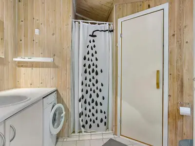 a bathroom with a shower with a shower curtain at Holiday home with spacious garden in Løkken