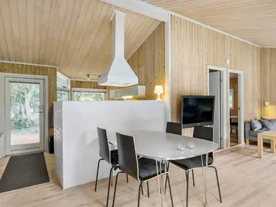 a dining room with a white table and chairs at Holiday home with spacious garden in Løkken