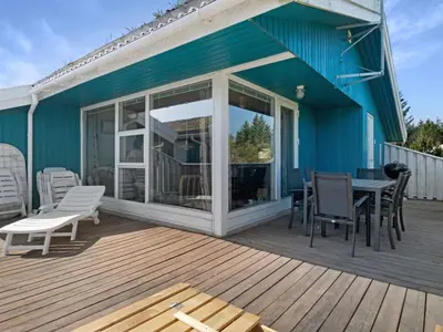 a deck with a table and chairs on a house at Green Oasis near Blokhus - By Traum Ferienwohnungen in Blokhus