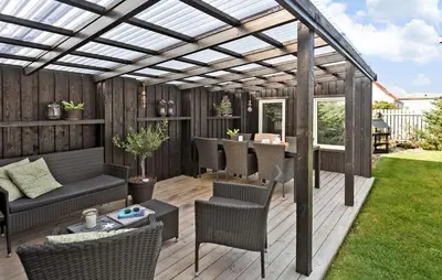 a pergola on a deck with a table and chairs at 4 Bedroom Awesome Home In Thisted in Thisted